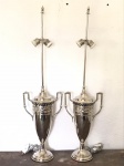 Par de ânfora em metal espessuradas a prata, adaptadas para abajures com 2 pontos de luz. Med. 87x23 cm.