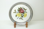FAIANÇA EUROPÉIA - Bela bandeja redonda em faiança com decoração floral policromada, arrematada em largo aro em metal espessurada a prata. Dia. 30 cm.