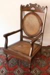 Antiga cadeira para calçar botas em madeira nobre clara, encosto e acento em palhinha indiana, pés torneados. Med. 96x57x49 cm, altura do assento 29 cm. Palhinhas no estado.
