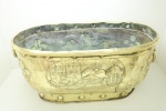 Grande cachepô oval em metal dourado de origem européia (França), ricamente decorado em relevo, castelo. Séc. XIX. Med. 32x68x36 cm. Sem o fundo.