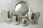 CHRISTOFLE-FRANCE. Aparelho para chá e café francês espessurado a prata estilo art deco, circa 1900. Corpo liso com alças e bicos em feitio de junco. Puxadores das tampas em feitio de carrapeta. Isoladores em osso. Composto de: Tabuleiro redondo com alça, bule de café, bule de chá, leiteira e açucareiro. Banho em bom estado.