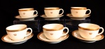 PORCELANA - Lote de conjunto em porcelana em tom marfim com bordas ricamente douradas e gravadas com delicada coroa, composto de: 6 xícaras de chá com seus respectivos pires. Med. 6x9 cm e 14 cm.