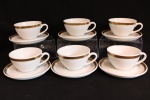 PORCELANA - Lote de conjunto em porcelana em tom branca com bordas ricamente douradas, composto de: 6 xícaras de chá e seus respectivos pires. Med. 6x10 cm e 14 cm.