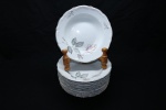 PORCELANA - Lote de conjunto em porcelana em tom branca com bordas levemente recortada, decorada com delicadas rosas policromadas e frisos dourados, composto de: 12 pratos fundos. Dia. 23 cm.