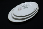 PORCELANA - Lote de parte de jogo de jantar em porcelana em tom branca com bordas levemente recortada, decorada com delicadas rosas policromadas e frisos dourados, composto de: 3 travessas ovais. Maior 36x24 cm e menor 28x18 cm.