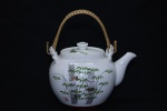 PORCELANA ORIENTAL - Belo bule de chá em porcelana oriental decorada com pintura de bambus, alça em fibra sintetica. Ass. selo vermelho. Med. 15x20 cm.