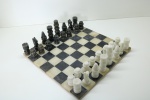 JOGO DE TABULEIRO - Xadrez  com tabuleiro em ônix preto e branco e peças em pedras de mármore pretos e brancos. (1 das pedras quebrada). Med. 35x35 cm.