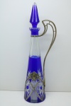 CRISTAL EUROPEU - Belíssima garrafa em cristal double lapidado, cor predominante azul, guarnecida com prata de lei contratada. Alt. 43 cm.