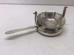 PRATA DE LEI - Coador de chá em prata peruana, teor 925 mls com suporte, ambas peças contrastadas, 82 gr. Med. 5x14 cm. PEÇA NÃO EXPOSTA NO LEILÃO, A MESMA ENCONTRA-SE NO COFRE DO BANCO.