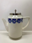 FAIANÇA EUROPÉIA -  Lindo bule em faiança européia branca decorada com orquideas policromadas e tampa em metal espessurado a prata. Alt. 20 cm. Bico serrado.