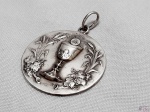 Medalha com cálice JHS em prata de lei. Medindo 3,3cm de diâmetro, pesando 10 gramas.