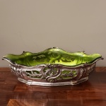 Floreira  de metal: espessurado a prata, com recipiente de vidro na cor verde.  Medidas aproximadas: 45 cm x 26 cm x 11 cm de altura.