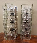 Elegante par de arandelas, década de 1960, executado em metal cromado e revestida por placas de vidro prensado. Medidas aproximadas: 13 cm x 15 cm x 40 cm de altura.