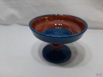Pequena fruteira com pé em cerâmica vitrificada azul com marrom. Medindo 15,5cm de diâmetro x 11,5cm de altura.