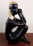 FIGURA FEMININA, porcelana, escultura preta e dourada, 25cm, não assinada.