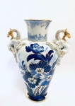 Vaso em porcelana década de 1950, pintado à mão, decoração em motivos florais no tom azul, com dourações e alças em formato de dragão. Med. 30x26 cm. 