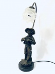 Belíssima Luminária em bronze ornada com escultura de menino segurando bola junto ao corpo, assinada J. Marie, base redonda em mármore. Med. 65x14 cm. 