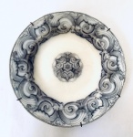 Prato de parede em porcelana branca com decoração em arabescos na cor cinza. Med. 23 cm. 