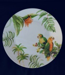 Prato em porcelana decorado com casal de papagaios. Med. 27 cm.