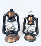 Dois Lampiões de funcionamento à pilha, com faltas (vidro e parte superior de um deles), não testados. Med. Maior: 30 cm. Menor: 27 cm. 