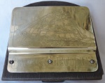 METAL DOURADO - Porta cartas com fundo em madeira e frente em metal dourado, decorado com relevo com Barco a velas. Med. 23x20 cm.