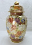 PORCELANA ORIENTAL - Potiche em porcelana ricamente policromada com motivo florais, fartamente dourada. Alt. 26 cm.