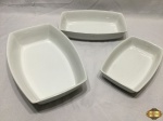 Jogo de 3 travessas retangulares em porcelana refratária branca. Medindo a maior 31,5cm x 21cm x 6,5cm de altura.