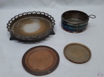 Lote composto de salva em latão, salva em cobre, salva com pé em prata 90 e descanso de garrafa em prata 90. Medindo a salva redonda com pé 19,5cm de diâmetro x 4cm de altura. Peças necessitam de limpeza, a salva com pé está com desgaste no banho.