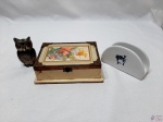 Lote diverso, composto de caixa em madeira, 1 porta guardanapo em porcelana e 1 enfeite de coruja em metal. Medindo a caixa 15,5cm x 11,5cm x 4,5cm de altura.