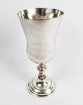 MUITO GRANDE E IMPORTANTE VASO PURIFICATÓRIO EM PRATA DE LEI BATIDA. ESTRUTURA DESMONTÁVEL EM TRÊS PARTES COMO DEVE SER NA DOS BONS VASOS SETECENTISTAS. IMPRESSIONANTE PELA GRANDE DIMENSÃO. PODE-SE OBSERVAR O BELISSIMO TRABALHO BATIDO NA PRATA TANTO NA PARTE INFERIOR DA BASE, QUANTO NA PARTE INTERNA DO COPO. O FUSTE É HARMONICAMENTE EXECUTADO COM FEITIO DE BALAÚSTRE. PEÇA DIGNA DE MUSEU, CERTAMENTE PERTENCEU A GRANDE IGREJA PAROQUIAL. BRASIL, PRINCíPIO DO SEC. XVIII. 33 CM DE ALTURA.NOTA: Esse elemento de Alfaia era empregado no ritual litúrgico de purificação nas missas até meados do sec. XIX. Esse vaso ou grande cálice representava o símbolo da purificação. Os  vasos eram grandes, bojudos, mas seu fuste não poderia ser mais elevado do que os cálices do vinho da eucaristia da missa nem poderiam ser de ouro ou prata dourada. Antes da comunhão o Acólito levava o vaso até os fiéis contendo água e coberto por um pano de linho feito especialmente para esse fim. A água era o elemento da purificação. Antes de receber o corpo do Senhor, cada fiel levava o cálice à boca, depois que tomava a água o Acólito passava o pano de linho na borda do vaso e o oferecia ao próximo fiel. Por volta de 1850 esse ritual foi eliminado da liturgia da missa para evitar a propagação de doenças. Por terem sido abolidos há cerca de 150 anos esses vasos são extremamente raros constituindo-se verdadeiras peças de museu e alto colecionismo.