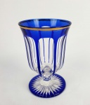 BARÃO DE ÁGUA BRANCA  BACCARAT  LINDA E ROBUSTA TAÇA EM CRISTAL DE BACCARAT COM LAPIDAÇÃO HARCOURT NAS TONALIDES AZUL E TRANSLÚCIDA,  MODELO CRIADO EM  1831. BORDA FILETADA EM OURO. PERTENCEU AO SERVIÇO DO BARÃO DE ÁGUA BRANCA, JOAQUIM ANTONIO DE SIQUEIRA TORRES (ÁGUA BRANCA, ALAGOAS, 1808-1888) E FOI A TAÇA UTILIZADA PELO GOVERNADOR DE ALAGOAS REFERENCIADA NA HISTÓRIA CONTADA NO LOTE ANTERIOR. FRANÇA, SEC. XIX. 13 CM DE ALTURANOTA: O CANGACEIRO LAMPIÃO E A BARONESA DE ÁGUA BRANCA  A Crônica Alagoana registrou o saque do Cangaceiro Lampião e seu bando ao SOLAR DO BARÃO DE ÁGUA BRANCA. Nesse tempo já havia falecido o barão há mais de três décadas mas vivia entretanto a Baronesa viúva dona  Joana Vieira de Siqueira Torres, nonagenária, que enfrentou o grupo de Lampião em 26.06.1922. Sinhô Pereira emprestou parte do seu bando para a invasão de Água Branca (AL). Os versos de Versos de Manoel DAlmeida Filho, publicados no folheto de cordel Os cabras de Lampião contam: "Foi ao Palacete da Viúva Joana Vieira, Baronesa de Água Branca, Numa 'entrevista' ligeira, Levou-lhe todas as jóias Para aumentar sua 'feira'". Virgulino Lampião há tempos vivia pedindo dinheiro à Baronesa, e esta de pronto respondia: "Tenho vinte contos, mas é para comprar de munição para o couro dele!". Diante da negativa da Baronesa, Lampião planejou um assalto à cidade de Água Branca. Claro, ele esperou um ano depois da resposta da Baronesa, pois ela havia enchido as ruas de jagunços, temendo alguma ação do cangaceiro. Desfeita a tensão, Virgulino enviou um espião à feira de Água Branca, a fim de verificar as forças policiais. Enquanto isso, Lampião esperava as notícias em Bom Conselho de Papacaça. Depois de ficar informado sobre a situação de Água Branca, Lampião rumou em direção ao município. Foram quatro noites de viagem, sendo que os dias serviam para o descanso de Lampião. Na tarde do dia 27 de junho de 1928, o cangaceiro tomou um sítio não muito longe de Água Branca e obrigou o dono a fazer compras na cidade. Deu-lhe dinheiro e uma lista, que continha cigarros, fósforos, esteiras de pipiri, duas redes brancas e uma lata de tinta vermelha. Para ter certeza que o dono do sítio ficasse em silêncio, Lampião manteve a família dele como refém. Caso abrisse o bico, Lampião prometeu judiar e até mesmo matar todos os familiares. Lampião dividiu seu bando estrategicamente. Quatro duplas se formaram para fazer o bloqueio das entradas da cidade e ali ficarem até o término do assalto. Os outros dez cangaceiros encheram as duas redes compradas no comércio com armas e munições. A lata de tinta vermelha serviu para pintar as redes, dando assim a impressão de sangue de morto. Ao amanhecer do dia 28, os dez cangaceiros entraram em Água Branca, carregando as redes com os dois "defuntos". Estacionaram em frente ao quartel da cidade e avisaram ao soldado de vigia: "isto foi dois que nós achou morto e truxemo para fazer o corpo delito". O vigia os convidou para entrar e esperar, enquanto ele iria acordar um outro soldado numa casa vizinha. Quando o vigia saiu atrás de ajuda, os cangaceiros trataram de pegar as armas escondidas dentro das redes e esperam a volta para dar o bote. Quando os guardas voltaram, Lampião mostrou as armas e disse: "o defunto é esse, visse?". Lampião soltou vinte presos e no lugar deles prendeu todos os guardas. Obrigou ainda ao corneteiro dar toque de reunir. Ao todo, Lampião enjaulou mais de trinta soldados e roubou todas as armas e munições, que logo foram distribuídas entre os ex-prisioneiros. Agora Lampião contava com trinta homens armados prontos para o assalto. Os cangaceiros tomaram as ruas e acordaram os moradores com tiros. As casas e as lojas dos mais ricos foram sendo saqueadas uma por uma. A Baronesa foi a que sofreu o maior prejuízo: trinta contos de réis em dinheiro, ouro, jóias, roupas e vinte e cinco cabras leiteiras. Após o saque, a Baronesa ainda seria humilhada a passear de braço dado com Lampião pelo meio das ruas da cidade. Em Água Branca, pela primeira vez os cangaceiros, entusiasmados pela vitória, cantaram o hino de guerra "Mulher Rendeira", um xaxado ritmado pela batida forte dos rifles batendo no chão: "Olê mulé rendeira/ olê mulé rendá/ tu me ensina a fazer renda/ que eu te ensino a namorar".