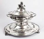 MAJESTOSO CENTRO DE MESA COM ESTILO GEORGIANO EM PRATA DE LEI BATIDA E REPUXADA COM SEU PRESENTOIR. ELEGANTE FEITIO! O PRESENTOIR CONVEXO É ELEVADO NO CENTRO E POSSUI ENCAIXE PERFEITO PARA O PÉ DA GRANDE SOPEIRA A BASE. DESSA FORMA O PRESENTOIR  FUNCIONA COMO UM EXPOSITOR QUE ELEVA A SOPEIRA. DECORADO COM LINDAS GUIRLANDAS RELEVADAS. A PEGA ROBUSTA E ELEGANTE TEM MOTIVOS VEGETALISTAS COM FLORES E RAMAGENS.  TRATA-SE DE TRABALHO PROVAVELMENTE PORTUGUÊS DE EXCEPCIONAL QUALIDADE! SEC. XIX/XX. 49  X 40 CM. 4033 G.