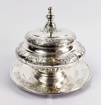 MIGUEL JOSÉ DE SÃO CLEMENTE  BELO CENTRO DE MESA COM PRESENTOIR EM PRATA DE LEI. ELEGANTEMENTE DECORADO COM GUIRLANDAS VEGETALISTAS CIRCULARES. AS PEÇAS POSSUEM CAPRICHADO MONOGRAMA EM PRATA COM VERMEIL COM AS INICIAIS MJC ENTREÇADAS. PERTENCEU A MIGUEL JOSÉ DE SÃO CLEMENTE FILHO DO SEGUNDO BARÃO DE SÃO CLEMENTE E ADMINISTRADOR EM NOME DA BARONESA VIÚVA DA BICENTENÁRIA FAZENDA AREIAS (VIDE IMAGEM DA FAZENDA AREIAS NOS CRÉDITOS EXTRAS DESSE LOTE). EUROPA, INICIO DO SEC. XX. 28 CM DE DIAMETRO. 1575 GNOTA: A Fazenda Areias é conhecida por sua importância histórica. Pertenceu inicialmente ao Barão de Nova Friburgo, ANTONIO CLEMENTE PINTO. Existe na propriedade uma jabuticabeira plantada pela Princesa Isabel em uma de suas visitas aos CLEMENTE PINTO já sob a gestão do CONDE DE SÃO CLEMENTE. Para construção da sede o conde contratou os serviços do Engenheiro holandês Jácob Van Erven, que, mais tarde, tornou-se seu sócio e administrador em diversas fazendas da família. O Conde terminou as obras da ferrovia iniciadas pelo Barão. Ao aposentar-se das atividades profissionais que desenvolvia na Corte até 1888 foi residir na fazenda. Com a morte do Conde a Propriedade foi herdada por seu filho, segundo barão de São Clemente, Antonio Clemente Pinto Neto. Após o falecimento do Barão de São Clemente, o filho Miguel José de São Clemente administrou a propriedade em nome da baronesa viúva. 