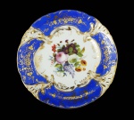 BARÃO DE ITACURUÇÁ MANOEL MIGUEL MARTINS O GRANDE ARREMATANTE DOS LEILÕES IMPERIAIS APÓS A PROCLAMAÇÃO DA REPÚBLICA. MAGNIFICO PRATO EM PORCELANA COM EXUBERANTE BORDA EM AZUL REMATADA EM OURO COM CACHOS DE UVAS E PARRAS. PALMÁCEAS RELEVADAS COMPLETAM A DECORAÇÃO. CALDEIRA COM LUXURIANTE DECORAÇÃO FLORAL. MARCAS DA CASA COMERCIALB WALLERSTEIN & CIA IMPORTADORA DO RIO DE JANEIRO. REPRODUZIDO NA PAGINA 274 DO LIVRO LOUÇA DA ARISTOCRACIA NO BRASIL DE JENNY DREYFUS E NA PAGINA 44 DO LIVRO LOUÇA HISTÓRICA MUSEU DE ARTE DA BAHIA. EXISTE UMA HIPÓTESE DEFENDIDA ENTRE COLECIONADORES DE LOUÇA DA ARISTOCRACIA BRASILEIRA QUE ESTE SERVIÇO É NA VERDADE UM DOS SERVIÇOS IMPERIAIS DE DOM PEDRO II ARREMATADO EM UM DOS LEILÕES DOS PAÇOS IMPERIAIS APÓS A PROCLAMAÇÃO DA REPÚBLICA. TAL HIPÓSTESE NÃO É INVEROSSÍMEL UMA VEZ QUE O SERVIÇO ATRIBUIDO AO BARÃO É MUITISSIMO PARECIDO COM O SERVIÇO DE CAÇA DE DOM PEDRO II E O BARÃO FOI O MAIOR ARREMATANTE DOS BENS IMPERIAIS OFERTADOS NO LEILÃO PROMOVIDO PELA REPÚBLICA NASCENTE. FRANÇA, 23 CM DE DIAMETRO. NOTA: Manoel Miguel Martins Barão de Itacurussá, nasceu em10 de novembro de 1831 em Sant'Ana do Itacurusá e faleceu em 01 de janeiro de 1911, filho de João Martins e de Gertrudes Margarida. Casou em 09 de março de 1867, no Rio de Janeiro, com Jerônyma Eliza de Mesquita, Baronesa de Itacurusá nascida em 02 de junho de1851 no Rio de Janeiro/RJ e batizada na Igreja de Santa Rita, e falecida em 24 de setembro de 1917, filha de Jerônymo José de Mesquita Conde de Mesquita e deElisa Maria de Amorim. Casaram-se em 09 de março de 1867 (portanto Jerônima estava com 16 anos de idade) na Igreja de S. Francisco Xavier. Título nobiliárquico de Barão de Itacurussá outorgado , em 25 de março de 1888, a Manuel Miguel Martins era um título de origem toponímica. Ilha e povoação do Estado do Rio de Janeiro, lugar de onde era natural este titular. Foi um homem riquíssimo, proprietário de terras e capitalista do Rio de Janeiro. Sua esposa a baronesa Jerônima Elisa de Mesquita Martins, era filha do conde de Mesquita e neta do marquês de Bomfim. O Barão foi o grande comprador do Leilão do Paço Imperial, onde além de muitas preciosidades, adquiriu todo o serviço de porcelana do casamento de D. Pedro I e D. Amélia de Leuchtemburg.