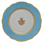 CONDE DE SÃO CLEMENTE  PRATO RASO EM PORCELANA PERTENCENTE AO  SERVIÇO DO CONDE DE SÃO CLEMENTE ( ANTÔNIO PEREIRA PINTO ). BORDA RECORTADA COM LARGO BARRADO EM  AZUL DELIMITADO POR FRISOS GRAVADOS A OURO. OSTENTA NA CALDEIRA, BRASÃO DO TITULAR SOB COROA DE CONDE ENCIMADA POR ÁGUIA NEGRA, TIMBRE DA FAMÍLIA SÃO CLEMENTE PROVENIENTE DA CIDADE DO PORTO. MARCAS DA MANUFATURA I.GAUVAIN. EXEMPLAR COMO ESTE ESTÁ REPRODUZIDO À PÁG. 320 DO LIVRO LOUÇA DA ARISTOCRACIA NO BRASIL DE JENNY DREYFUS. FRANÇA, SEC. XIX,  23,5 CM DE DIÂMETRO.NOTA: BRASÃO DO CONDE DE SÃO CLEMENTE:  Escudo partido em pala: na primeira em campo de ouro,cinco crescentes de lua de azul, postos em aspa; na segunda as armas dos Vasconcellos que são: em campo preto, três faixas, veiradas e contraveiradas de prata e goles. TIMBRE: uma águia de preto,estendida.