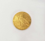 5 DOLARES AMERICANOS - RARA MOEDA COM VALOR DE 5 DOLARES CONHECIDA COMO INDIAN HEAD HALF EAGLE. CUNHADA EM OURO 22 K PELA CASA DA MOEDA DA FILADÉLFIA EM 1911. EUA, 8,36 GNOTA: Em janeiro de 1914, com a Europa à beira da guerra e os Estados Unidos no meio de uma depressão, Henry Ford anunciou que estava dobrando o salário de seus trabalhadores de $ 2,34 por dia para $ 5 e, ao mesmo tempo, reduzindo sua jornada de trabalho de nove horas a oito horas. A Ford Motor Company estava, disse ele, iniciando "a maior revolução em matéria de recompensas para seus trabalhadores já conhecida no mundo industrial". Por mais estranho que possa parecer na economia inflacionada de hoje, US $ 5 por dia era de fato um belo salário em 1914, e o que Ford fez foi tão revolucionário quanto ele proclamou. Claramente então, a meia águia - ou moeda de ouro de $ 5 - era uma moeda com considerável influência em 1914, embora fosse apenas um pouco maior do que o então novo níquel Buffalo. Afinal, representava o pagamento de um dia inteiro para trabalhadores bem pagos - o suficiente para comprar um par de calças e um par de botas de trabalho. As meias-águias sendo cunhadas naquele ano tinham mais em comum com os níqueis Buffalo do que o tamanho: ambas carregavam retratos de índios americanos de aparência realista. A meia águia Indian Head fez sua primeira aparição em 1908, junto com um quarto de águia (ou moeda de ouro de US $ 2,50) de desenho idêntico. Em outro aspecto, no entanto, essas peças de ouro da Cabeça Indiana são diferentes de quaisquer outras moedas produzidas antes ou depois pelos EUA: seus desenhos e inscrições estão em baixo relevo na superfície das moedas, em vez de serem elevados. Essa técnica inovadora era bastante ousada, pois nenhuma outra moeda moderna a havia usado. Em tempos normais, na verdade, a ideia poderia muito bem ter sido descartada. Mas novas idéias eram bem-vindas nos assuntos nacionais no início dos anos 1900, em grande parte graças a um indivíduo extraordinário: o presidente Theodore Roosevelt. O inquieto e dinâmico Roosevelt se interessou pessoalmente por praticamente todos os aspectos da cena americana - incluindo a moeda da nação - e deixou sua marca pessoal em muitas áreas. Roosevelt persuadiu o principal escultor do país, Augustus Saint-Gaudens, a redesenhar a águia dupla e a águia (peças de ouro de US $ 20 e US $ 10) e ficou muito orgulhoso quando as duas novas moedas foram lançadas em 1907 e receberam críticas entusiasmadas. Em 1908, ele voltou sua atenção para as duas moedas de ouro restantes, a meia águia e a  águia. A ideia de rebaixar as características das moedas veio de William Sturgis Bigelow, um médico de Boston e amante da arte que por acaso era um amigo próximo de Roosevelt. Bigelow viu um relevo incuso em obras de arte egípcias no Museu de Belas Artes de Boston e despertou o interesse do presidente com sua noção de adaptar essa técnica à cunhagem dos Estados Unidos. Com a bênção de Roosevelt, ele contratou um colega de Boston, o famoso escultor Bela-Lyon Pratt, para preparar modelos de cunhagem, e Pratt desenvolveu desenhos emparelhando um bravo indiano no anverso com uma águia em repouso no reverso. As novas moedas devem ter confundido muitos americanos quando entraram em circulação no final de 1908. Além de seu relevo incomum, elas também representaram a primeira mudança fundamental de design nas duas denominações em quase 70 anos. Além da adição das palavras EM DEUS QUE CONFIAMOS em 1866, a meia águia anterior - que carregava um retrato da Liberdade com uma coroa no cabelo - era basicamente a mesma desde sua origem em 1839. Consternação, não confusão, foi o que algumas pessoas sentiram quando viram as moedas. Um dos maiores críticos foi o negociante de moedas da Filadélfia, Samuel H. Chapman, que questionou tudo, desde a virilidade do índio (ele descreveu o retrato como "emaciado") ao risco à saúde representado pelo "desenho afundado" (ele previu que isso tornaria as moedas um grande receptáculo de sujeira e transportador de doenças). Críticos como Chapman estavam fadados ao desapontamento em sua tentativa de descarrilar as novas moedas, embora tivessem um aliado influente no gravador-chefe da Casa da Moeda dos Estados Unidos, Charles E. Barber. Defendendo zelosamente seu território, Barber fez modificações aparentemente desnecessárias nos designs de Pratt, assim como fizera antes com os modelos de Saint-Gaudens. Mas, em última análise, o apoio de Roosevelt era tudo o que importava. As meias-águias Indian Head foram emitidas anualmente de 1908 a 1916; em um ano, 1909, quatro casas da moeda diferentes as produziram (as edições da casa da moeda de ramos são indicadas por uma marca da casa da moeda no verso). Depois de 1916, a produção foi suspensa por 13 anos; em seguida, recomeçou para um último vivas em 1929 no Philadelphia Mint antes que a série terminasse para sempre em face da Grande Depressão. A meia águia de 1929 é a grande chave da série, valendo vários milhares de dólares, mesmo em em estado ruim. Os registros listam sua cunhagem como 662.000, mas a grande maioria aparentemente foi derretida. Outras datas raras incluem 1909-O, 1911-D e 1908-S, todas com moedas abaixo de 100.000. Um pequeno número de provas foi feito todos os anos de 1908 a 1915. Sendo recuados, os elementos de design nas meias-águias Indian Head são protegidos contra o desgaste pesado. Ao mesmo tempo, isso complica a classificação, uma vez que os padrões de desgaste diferem daqueles das moedas em relevo. As áreas críticas para a detecção de desgaste são as penas da maçã do rosto e do cocar do índio e o ombro da asa esquerda da águia. Embora essas moedas sejam abundantes em graus até Mint State-64, elas são bastante evasivas no MS-65 e muito raras acima desse nível. Embora seu design inovador tenha recebido críticas mistas, a meia águia Indian Head foi salva em seu primeiro ano de emissão. As peças da casa da moeda da Filadélfia de 1908 representam uma das datas mais disponíveis desta série em bom estado. Todos os outros problemas parecem ter sobrevivido a essa condição por mero acaso. Os exemplos de bom estado mais comumente vistos desse tipo são aqueles datados de 1909-D. Milhares apareceram em um tesouro alguns anos atrás. Embora as moedas desse tipo fossem geralmente bem cunhadas, o mesmo não se aplicava às suas marcas da casa da moeda. Como os únicos elementos elevados acima do nível do campo, essas letras minúsculas são freqüentemente encontradas superficiais e indistintas. Apenas um leve desgaste pode torná-los ilegíveis. Isso é especialmente verdadeiro para as moedas da casa da moeda de São Francisco, embora a meia-águia 1909-O também seja famosa por ter uma marca da casa da moeda que é difícil de distinguir, mesmo em moedas em excelente estado. Henry Ford provavelmente não estava pensando no Indian Head meia águia quando instituiu o dia de trabalho de US $ 5, mas a carreira da moeda parecia semelhante à de Ford: surgiu no mesmo ano que o Modelo T e deixou a linha de produção da Casa da Moeda dois anos depois que o Modelo T deu lugar ao Modelo A.