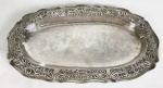 ANTIGA TRAVESSA EM PRATA REGIONAL BRASILEIRA, BATIDA, REPUXADA E CINZELADA. FEITIO OVAL E DECORAÇÃO EM ROCAILLE. BRASIL, SEC. XVIII/XIX. 37 CM DE COMPRIMENTO. 708 G.