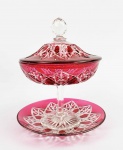 BACCARAT LAPIDAÇÃO COLBERT  LINDA COMPOTEIRA E SEU PRESENTOIR EM CRISTAL DOUBLE TRANSLUCIDO E CEREJA COM LAPIDAÇÃO MODELO COLBERT. FORMA PAR COM A OFERTADA NO LOTE ANTERIOR. TAMPA TEM PEGA COM LAPIDAÇÃO DIAMANTE E SOB A BASE LAPIDAÇÃO ESTRELA. FRANÇA, SEC. XIX. 25 CM DE ALTURA