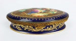LE TALLEC  LINDA CAIXA EM PORCELANA REMATADA EM BRONZE ORMOLU. TAMPA DECORADA COM SUNTUOSA RESERVA CONTENDO PÁSSAROS, ÁRVORE E FLORES. FUNDO EM PROFUSO OURO APLICADO EM RELEVO. NOTA: Camille Le Tallec nasceu em Paris com ascendência bretã de  Lorient e Picard.  Formou-se em 1929 na prestigiosa École du Louvre de Paris com uma tese sobre a porcelana Nast do século XVIII.   Ele então assumiu, em 1930, o estúdio familiar de porcelana pintada à mão fundado em Belleville (Paris) no início do século. Em 1961, Le Tallec iniciou uma colaboração frutífera com a empresa de prata e joalheria Tiffany & Co que levou em 1990 à incorporação do Atelier Le Tallec na empresa americana, um ano antes de sua morte em Paris.  Tiffany's e Le Tallec projetaram padrões de porcelana originais e particulares de sucesso que podem ser vistos tanto no Viaduc des Arts da promenade plantée no 12º distrito de Paris e em todas as lojas Tiffany's nos Estados Unidos. Mais de 60 anos, Le Tallec manteve a porcelana tradicional pintada à mão. Ele preservou e revisitou cerca de 375 padrões originais e históricos assinados pelas marcas do Le Tallec .  Atelier Le Tallec foi empossado como um membro dos Grands Ateliers de France (os cinquenta melhores estúdios da França) em 2000. Le Tallec também adquiriu de 1935 a 1955 peças de prestígio em porcelana europeia.  Sua coleção excepcional foi dispersa em leilão em 1990, e algumas obras-primas adquiridas por museus internacionais como o Louvre , o musée de la Faïence de Marseille e o musée de l'Île-de-France e várias porcelanas colecionadores.  Ele foi um Caveleiro de la Légion d'honneur nomeado em 1976 por um colega de escola: Edgar Faure , então presidente da Assembleia Nacional Francesa . Rapidamente, Le Tallec decidiu continuar na tradição da porcelana de Vincennes e da porcelana de Sèvres , expandindo o pequeno negócio local, o Atelier Le Tallec. Em trinta anos, o estúdio criou utensílios de mesa de porcelana pintados à mão para personalidades famosas como a Rainha Elizabeth II do Reino Unido , os Reis Mohammed V e Hassan II de Marrocos , a Vila de Paris ou a República Francesa, entre outros.