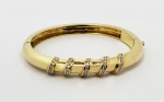 TADINI  BELO  BRACELETE EM OURO 18K COM CORAL LADEADO POR DOZE BRILHANTES EXTRA BRANCOS E COM MUITA VIDA. TRABALHO DO JOALHEIRO TADINI. ABERTURA DO TIPO ALGEMA COM FECHO  REFORÇADO. 6,5 CM DE DIAMETRO. 33,4 GNOTA: LUCIANO TADINI, foi um grande joalheiro italiano radicado em São Paulo. Sua ligação com joalheria começou na infância, em suas incursões na oficina de seu tio, também joalheiro. Foi lá que nasceu o interesse pelo ofício. Fez diversos cursos ainda na Itália e ao chegar ao Brasil ainda no início do ano de 1951, já era um conceituado profissional joalheiro. Suas joias aliam design e qualidade da produção de ourivesaria italiana.