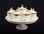 COMENDADOR LUIZ GOMES FERREIRA - LOTE COM OITO CREMEIRAS E PRESENTOIR EM PORCELANA DE PARIS COM DECORAÇÃO ESTILO  E ÉPOCA RESTAURAÇÃO, REINADO CARLOS X DA FRANÇA. DECORADOS EM OURO, RESERVAS COM BRASÃO DE ARMAS DO COMENDADOR E LEGENDA EM LATIM SOLA NOBILITAS VIRTUS. EM LETRAS GÓTICAS INICIAIS DO PROPRIETÁRIO LGF. DEC. 1820. 31  CM DE DIAMETRO (PRESENTOIR)