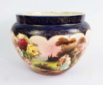 GRANDE FLOREIRO EM FAIANÇA COM DECORAÇÃO POLÍCROMA COM ROSAS E CENAS IDÍLICAS. BORDA EM AZUL COBALTO REMATADO EM OURO. ALEMANHA, SEC. XIX/XX. 39 X 30 CM