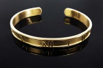 TIFFANY & CO  LINDA PULSEIRA BRACETE TIFANNY & CO ATLAS EM OURO 18K. REFINADA E ELEGANTE! APRESENTA ALGARISMOS ROMANOS INSPIRADA NO RELÓGIO ATLAS. 6,5 CM DE DIAMETRO. 32,7 G