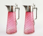 PAR DE BELOS DECANTERES EM VIDRO ARTÍSTICO MOULLE NA TONALIDADE ROSÊ DE FEITIO EM TORCEIL REMATADO EM OURO. GUARNIÇÃO EM METAL ESPESSURADO A PRATA. ESTILO E ÉPOCA ART NOUVEAU. TAMPAS BASCULANTES. PEÇAS MUITO ELEGANTES! EUROPA, INICIO DO SEC. XX. 27 CM DE ALTURA.