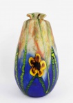 WILHELM KRALIK SOHN  GRANDE FLOREIRO EM VIDROM ARTÍSTICO ESTILO E ÉPOCA ART DECO. MAGNIFCA DECORAÇÃO COM FLORES E COLMOS VEGETAIS. PEÇA BELÍSSIMA! CHECOESLOVÁQUIA, DECADA DE 1930. 37 CM DE ALTURA.NOTA: A fábrica de vidros Lenor foi fundada por Jan Meyer em 1834 como uma das últimas na região checa de umava. Jan Meyer era o proprietário da fábrica de vidros em Vimperk, cuja capacidade se revelou insuficiente com o passar do tempo, e portanto não havia outra maneira a não ser construir uma nova fábrica.Mais tarde, a gestão da vidraria recém-fundada foi assumida por Wilhelm Kralik e, após a sua morte, pelos filhos de Wilhelm que, no entanto, não se entenderam quanto a administração e a empresa ficou assim dividida: Os irmãos Heindrich e Jan estabeleceram uma nova empresa, batizando-a de Wilhelm Kralik Sohn e datando sua fundação em 1830, ou seja, o período em que Wilhelm Kralik entrou na empresa de Jan Meyer. No início, a vidraria e seus novos proprietários foram fortemente afetados pelos problemas causados pela falta de experiência dos dois irmãos. Em 1882, a situação resultou na saída de Jan Kralik. Heinrich recebeu assim a rica experiência e conhecimento de negócios de seu primo, Wilhelm Mathias Kralik, que era o chefe da fábrica de vidro de Nov Svt na época. Ele chegou a umava com muitos de seus colaboradores de Harrachov. O novo diretor de negócios mudou drasticamente a gama de produção da vidraria, que até então se concentrava principalmente no vidro plano: a orientação principal era produzir o vidro decorado com fundição da moda com motivos naturalistas, atendendo assim à demanda dos clientes europeus. Isso garantiu as vendas em muitos países europeus. O vidro decorado com Lenora estava inicialmente muito próximo dos exemplos de Harrachov principalmente por seus tons suaves e escuros de verde oliva, marrom e topázio. Esses padrões geralmente tinham decorações naturalistas na forma de folhagens e flores e pequenos insetos, mas também cobras e lagartos. A vidraria Lenor, no entanto, encontrou sua expressão artística única ao longo do tempo, baseada em decorações específicas como flores prensadas planas com contrastes de cores marcantes e arranjos simétricos. Lenora, além disso, produziu uma grande escala de vasos e jardineiras, objetos de mesa decorativos na forma de flores e cúpulas em forma de pétalas. A vidraria atingiu seu auge durante a década de 1890, e muitos padrões e decorações característicos do vidro fundido decorado foram produzidos até a década de 1920, alguns deles até mesmo durante a década de 1940.