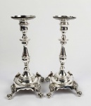 BELO PAR DE CASTIÇAIS EM PRATA DE LEI DITOS  DE GARRA E BOLA. DECORADOS COM GUILOCHES. FUSTE EM BALAÚSTRE. ASSENTE SOBRE QUATRO LINDOS PÉS EM GARRA E BOLA REMATADOS POR FOLHAS DE ACANTO. BRASIL, SEC. XIX. 24 CM DE ALTURA. 1265 G.