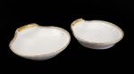 COMENDADOR LUIZ GOMES FERREIRA  PAR DE LINDOS COVILHETES EM PORCELANA COM ELEGANTE FEITIO DE CONCHAS. DECORAÇÃO ESTILO  E ÉPOCA RESTAURAÇÃO, REINADO CARLOS X DA FRANÇA. DECORADO  A BORDA TEM LARGO BARRADO EM OURO, SUCEDIDA POR FRISO AZUL DELIMITADO POR FRISO EM OURO. AS PEÇAS SÃO ESTRIADAS COMO CONCHAS DE VIEIRA. POSSUI BRASÃO DE ARMAS DO COMENDADOR E LEGENDA EM LATIM SOLA NOBILITAS VIRTUS. EM LETRAS GÓTICAS INICIAIS DO PROPRIETÁRIO LGF. FRANÇA, DEC. 1820. 22,5 CM DE COMPRIMENTO