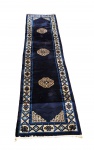 PEKIM - BELA PASSADEIRA ORIENTAL EM LÃ URDIDA MANUALMENTE. ELEGANTE PADRONAGEM E TONALIDADE EM AZUL E CREME. POSSUI CACHÊ DA CASA LUCIANO  COEN, LOCALIZADA EM ROMA, ITALIA. CHINA, MEADOS DO SEC. XX. 310 X 70 CMNOTA: A produção em tapetes na China é rica em história - os tapetes chineses foram tecidos pela primeira vez há séculos por tribos nômades nas regiões de Sinkiang e Ninghsia, no oeste da China - mas não foi até o final do século 19 que a fabricação dos tapetes para exportação começaram a ser intensificadas. Usando técnicas de tecelagem muito semelhantes às da Pérsia, Índia e Ásia Central, os tapetes chineses (Pequim) eram construídos principalmente com lã de ovelha, atada à mão em teares verticais. Alguns tapetes eram tecidos inteiramente de seda ou tinham fibras de seda, enquanto um número menor usava pêlos de cabras, camelos e iaques. Embora um nó turco fosse ocasionalmente usado para a borda do tapete, nós persas eram normalmente usados para o campo. O pelo era relativamente longo e o nó - em 30-60 KPSI - grosso, mas o fio era torcido tão frouxamente que suas pontas se abriam e se espalhavam em tufos que davam uma aparência de superfície mais densa e suave.