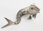 BELA ESCULTURA EM PRATA DE LEI COM FEITIO DE PEIXE ARTICULADO. OLHOS EM VERMELHO. ESPANHA, MEADOS DO SEC. XX. 22 CM DE COMPRIMENTO.