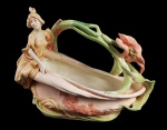 ROYAL DUX  MUITO GRANDE ESCULTURA EM FAIANÇA POLICROMADA COM FEITIO DE CESTA COM PERSONAGEM FEMININO ESTILO ART NOUVEAU. MARCAS DA MANUFATURA PARA A DÉCADA DE 1920. EXCELENTE ESTADO DE CONSERVAÇÃO!  ÁUSTRIA, PRIMEIRA METADE DO SEC. XX. 47 CM DE COMPRIMENTO.